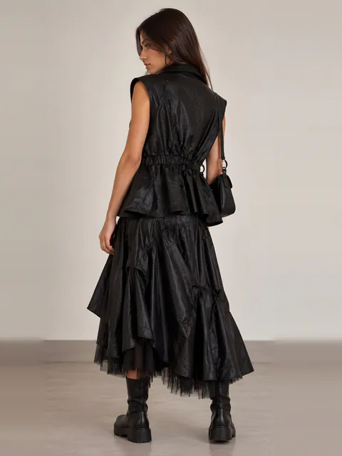 Black leather vest over a layered tulle skirt, back