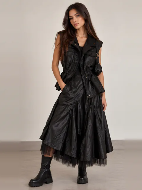 Black leather vest over a layered tulle skirt, front